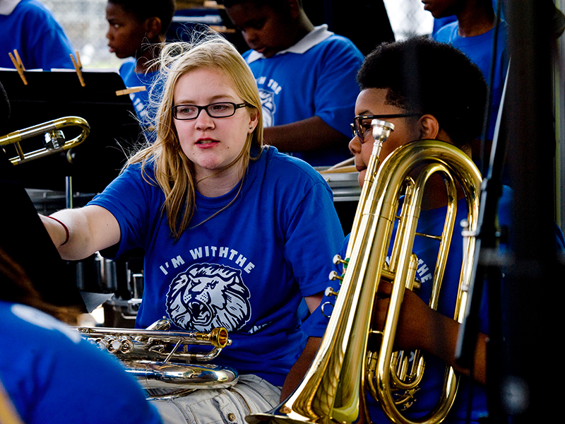 Tulane Service Learning student helping young band member